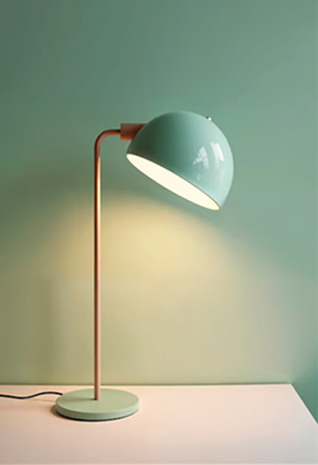 Lampe_N5IgV2 1 Eine moderne mintgrüne Schreibtischlampe mit rundem Schirm und schlankem Ständer sitzt auf einer weißen Fläche und wirft ein sanftes Licht auf die passende mintgrüne Wand - die perfekte Ergänzung für jeden kreativen werbeagentur Karlsruhe-Arbeitsplatz.